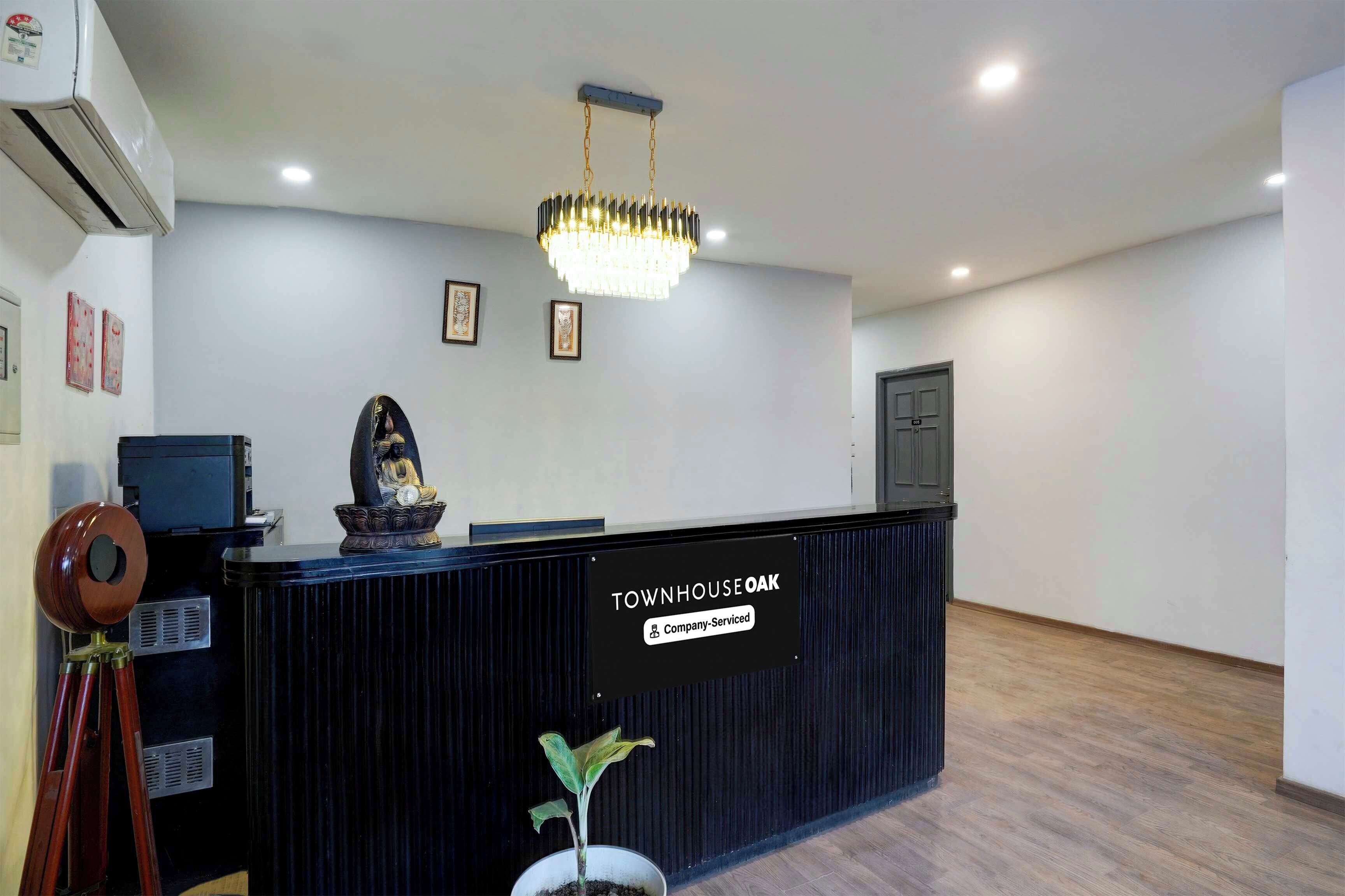 En receptionsdisk med et skilt, der viser 'TOWNHOUSE OAK Company Serviced'.