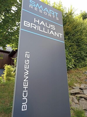 Señal para Smart Resorts Haus Brilliant, que indica el nombre y la ubicación del hotel.