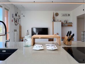A kitchen with a wooden table, a knife block, and two packets on the counter. - Casa Cenni | Bright 2BR, M1 & CityLife (Milano)