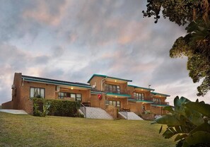 A two-story building with a brick facade, large windows, and a flat roof. - Club Hacienda Margate 2-bedroom WBT Rentals (Margate)