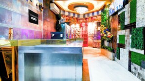 Un espace d’accueil avec un comptoir, un panneau indiquant « Service aux entreprises », et un mur décoratif agrémenté de plantes.