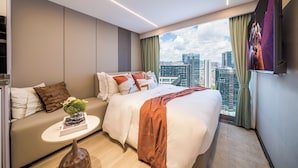 A modern hotel room with a city view, a bed, a sofa, and a small table with a vase. - Yunli Cloudtop Hotel (Guangzhou)