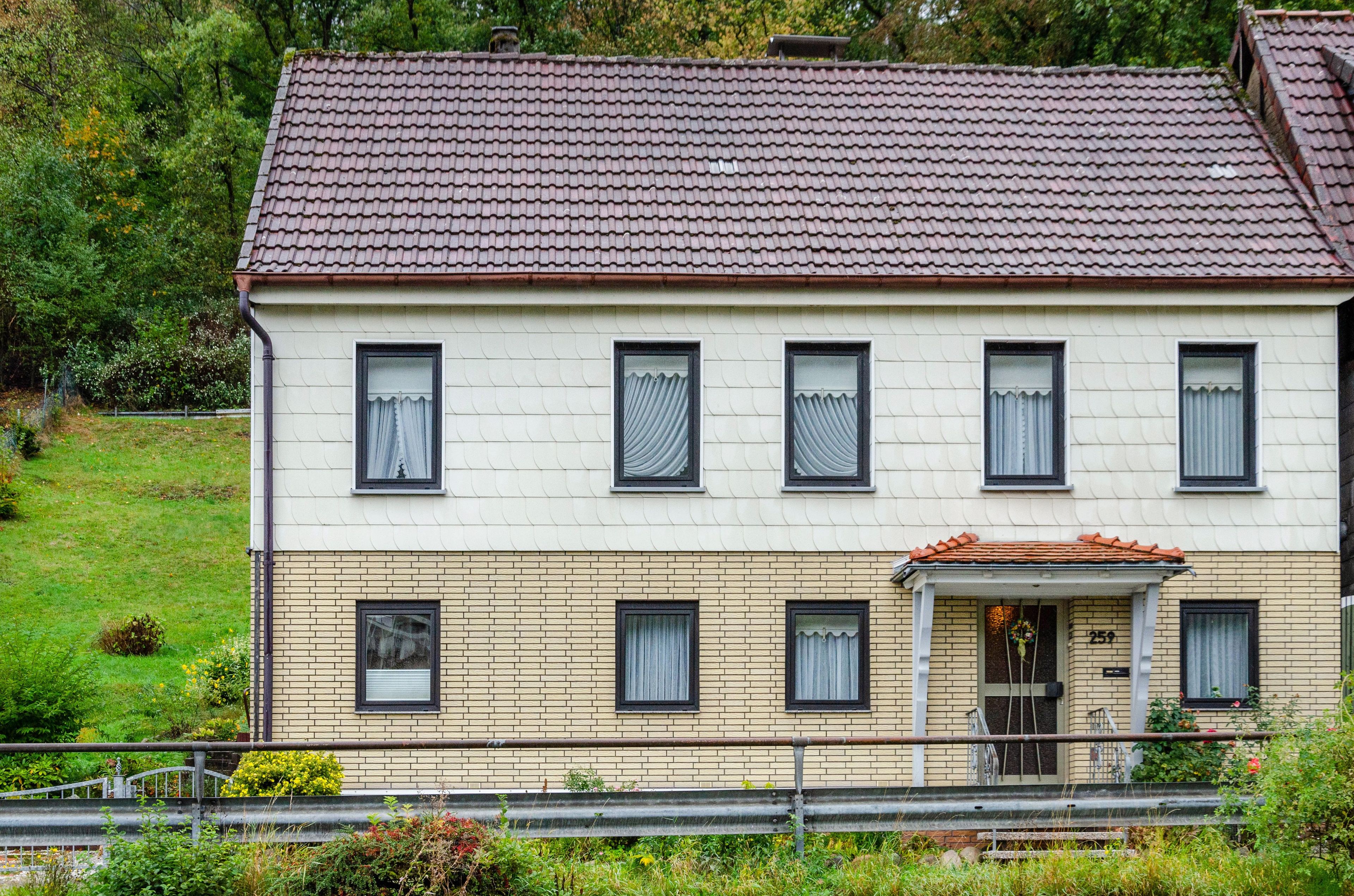 Un bâtiment à deux étages, doté d’un toit recouvert de tuiles, de nombreuses fenêtres et d’une façade en briques.