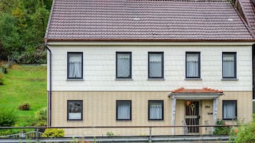 Un bâtiment à deux étages, doté d’un toit recouvert de tuiles, de nombreuses fenêtres et d’une façade en briques.
