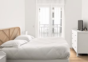 Un dormitorio con cama, mesita de noche, cómoda y ventana con vistas al exterior.