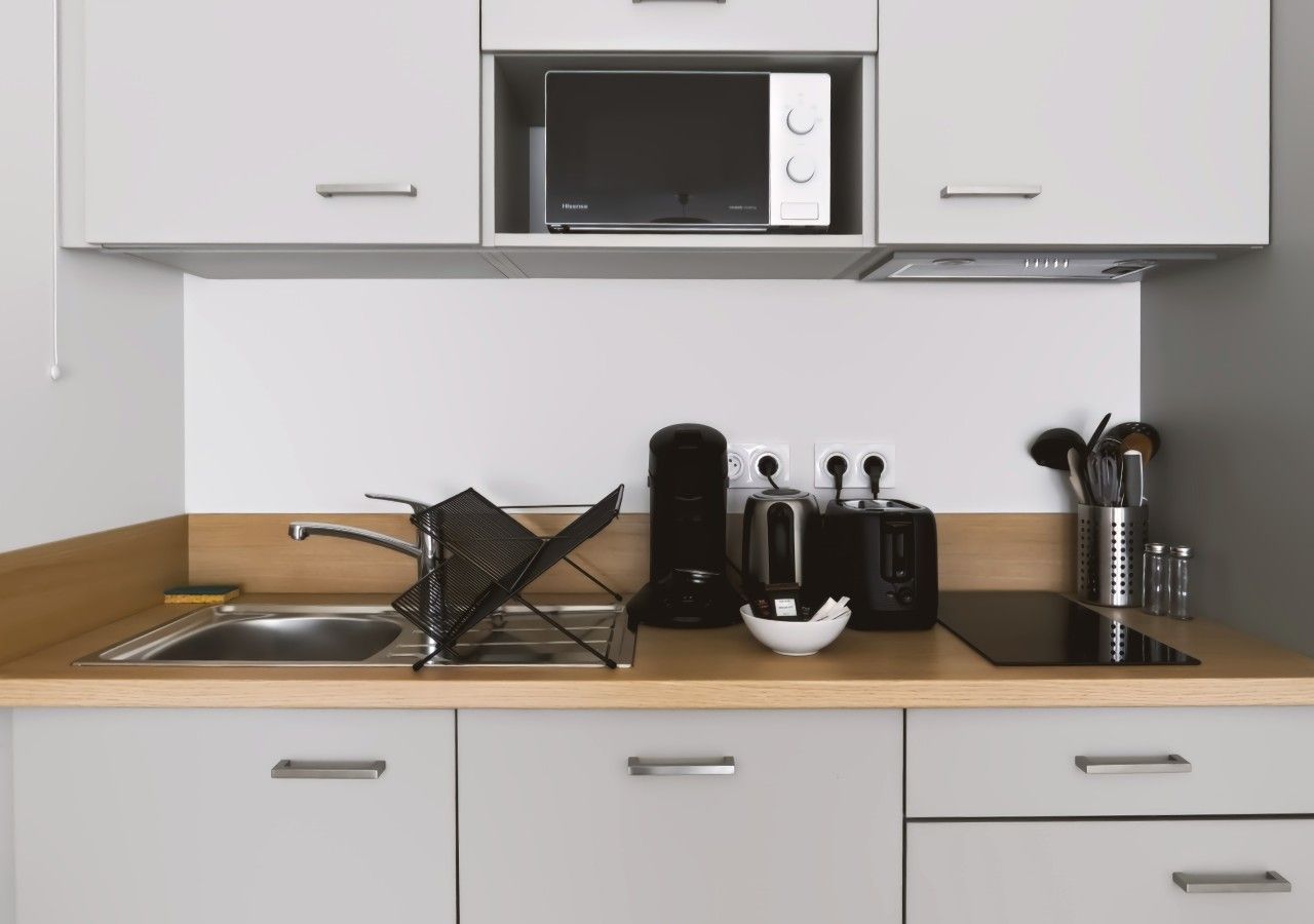 A modern kitchen with a microwave, sink, and various appliances.
