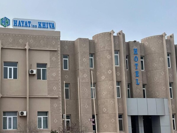 A hotel building with a sign reading 'Hayat Inn Khiva' and 'HOTEL' on the facade. - HAYAT inn KHIVA (Khiva)