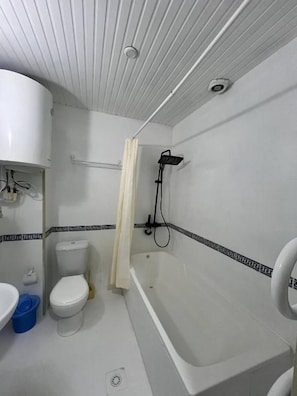 A bathroom with a toilet, sink, bathtub, and shower. - HAYAT inn KHIVA (Khiva)