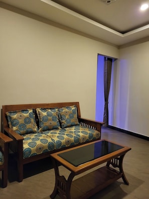Una sala de estar con un sofá y una mesa de centro de vidrio.
