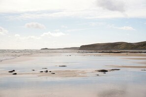 A beach with a sandy shore and scattered rocks.