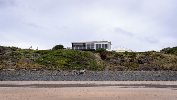 A coastal house with a modern design, situated on a hillside with a rocky beach in the foreground. - Shack Vibes, Direct Beach Access (Low Head)