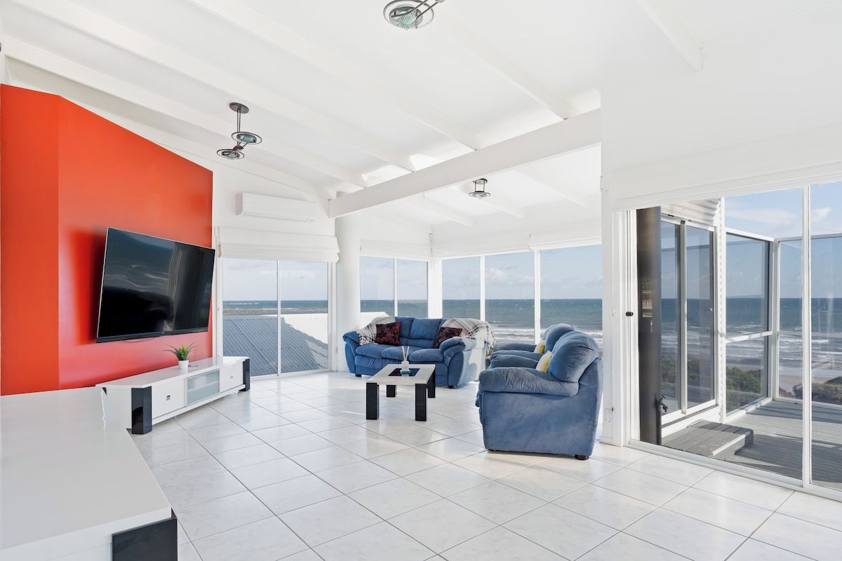 A modern living room with a large TV, a blue sofa, and a coffee table.