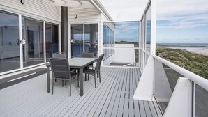 A deck with a table and chairs, overlooking a beach. - Shack Vibes, Direct Beach Access (Low Head)