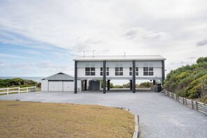 A two-story building with a flat roof, large windows, and a covered entrance area.