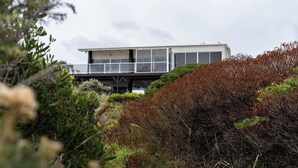 A modern house with a balcony, surrounded by dense shrubbery. - Shack Vibes, Direct Beach Access (Low Head)