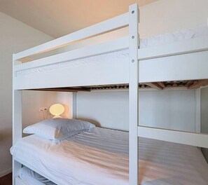 A bunk bed with a bedside lamp and a pillow. - Flat Le Tournoy – Sea View Koksijde (Koksijde)