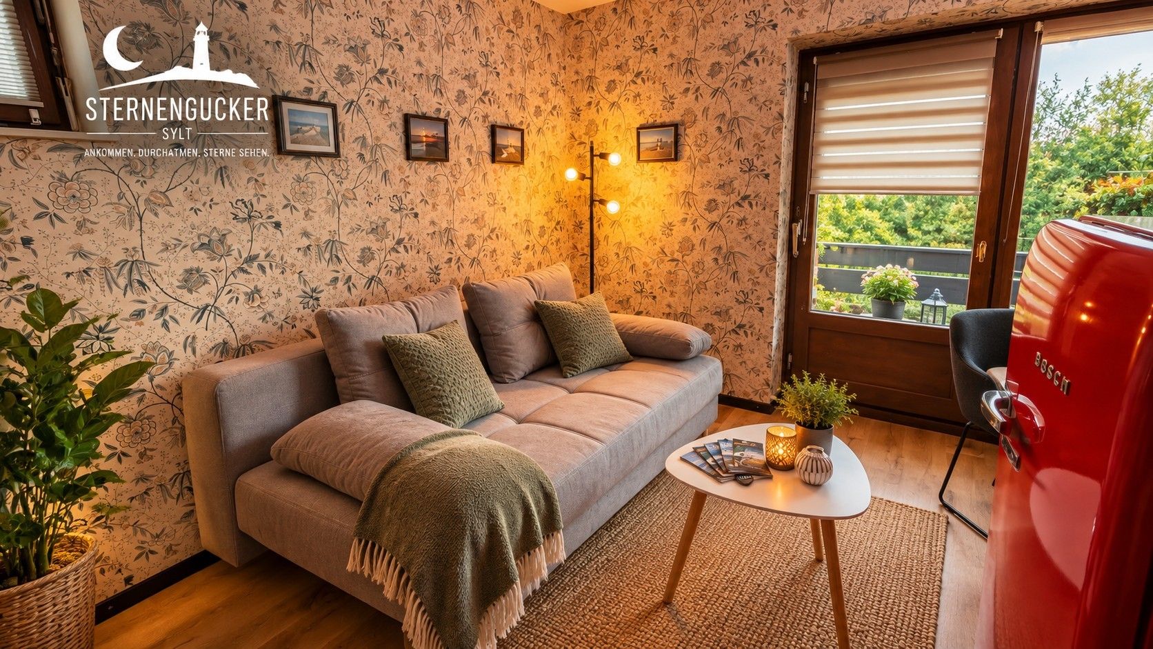 A cozy living room with a sofa, a small table with magazines, a red grill, and a window with a view.