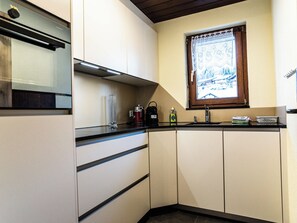 A kitchen with a built-in stove, a window with a view, and a sink. - Sportina 21 2. OG Süd-Ost Appartement/Fewo, Bad, WC by Interhome (Riederalp)