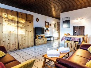 A cozy living room with a wooden cabinet, a television, and a dining area with a table and chairs. - Sportina 21 2. OG Süd-Ost Appartement/Fewo, Bad, WC by Interhome (Riederalp)