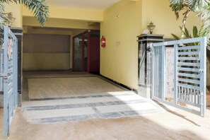A hallway with a tiled floor leading to a door with a red frame. - Super Townhouse Hitech City Madhapur (Hyderabad)