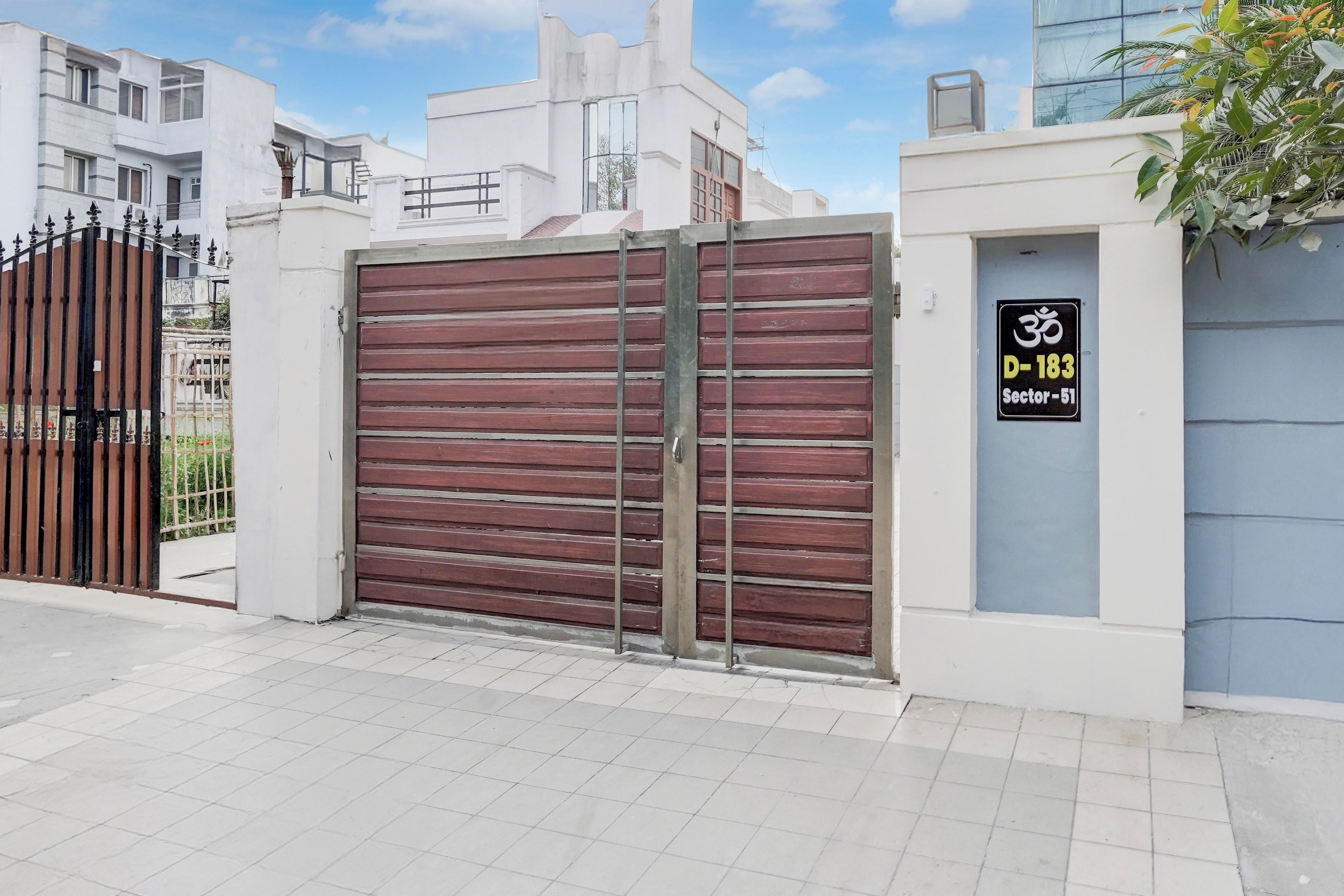 Una zona residencial cerrada con una reja metálica y un cartel que indica 'Sector-51'.