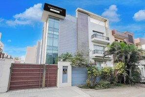 A modern townhouse with a prominent vertical design element, a gated entrance, and a clear sky. - Townhouse Sector 51 Noida (Noida)