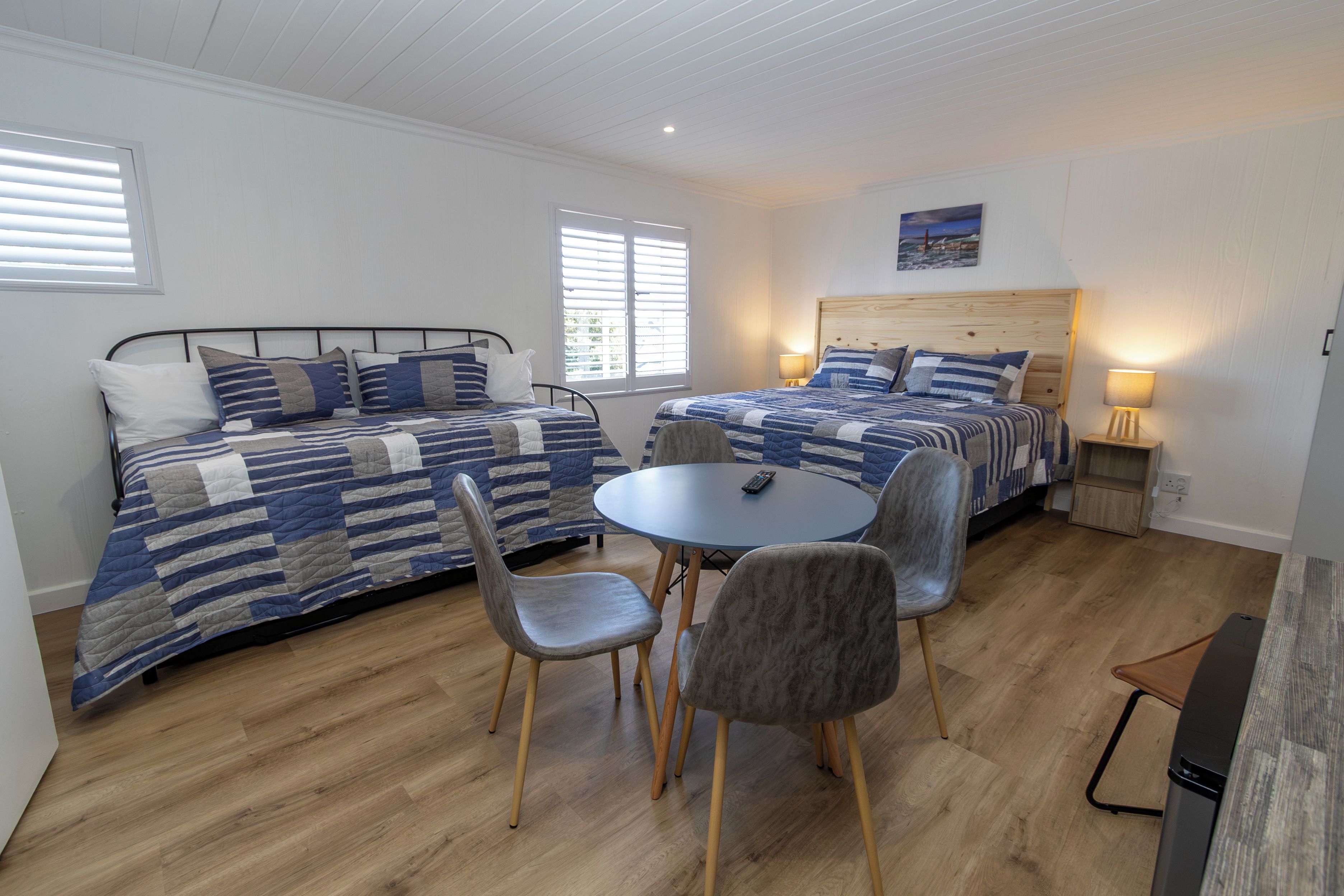 A double room with two beds, a round table, and two chairs.