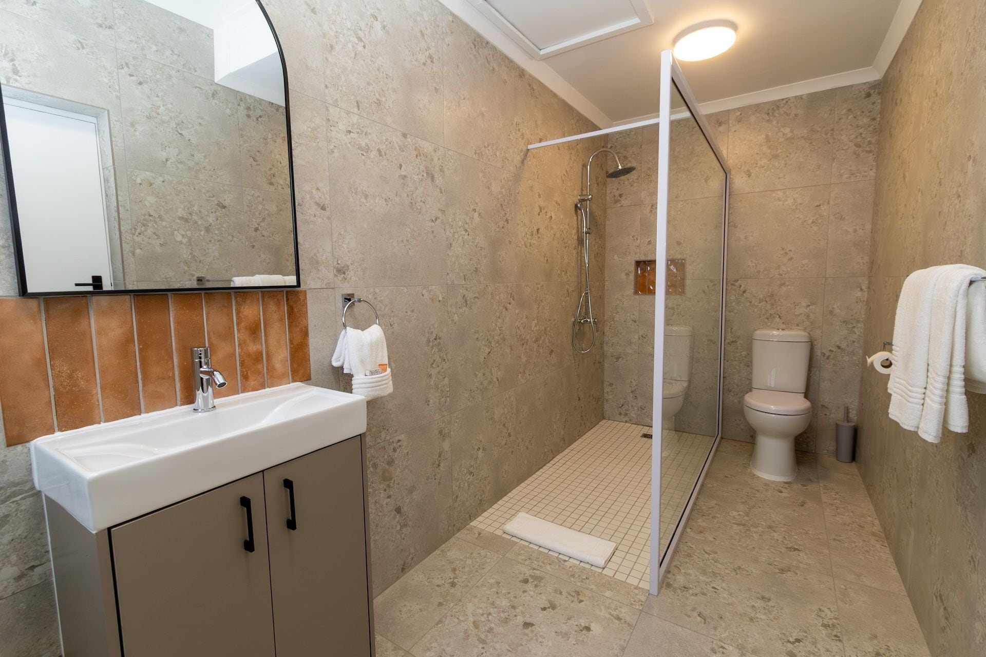 Ein modernes Badezimmer mit Dusche, Toilette und Waschbecken.