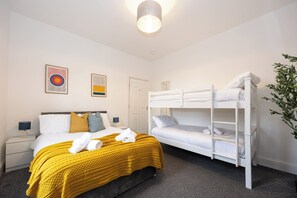 A hotel room with a bunk bed, a single bed, and a yellow blanket. - The Hale Loft- Sleeps 8 Village Location (Hale)