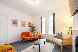 A living room with a sofa, a coffee table, a fireplace, and artwork on the walls. - The Hale Loft- Sleeps 8 Village Location (Hale)