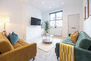 Ein stilvolles Wohnzimmer mit einer Couch, einem Sessel und einem Couchtisch.