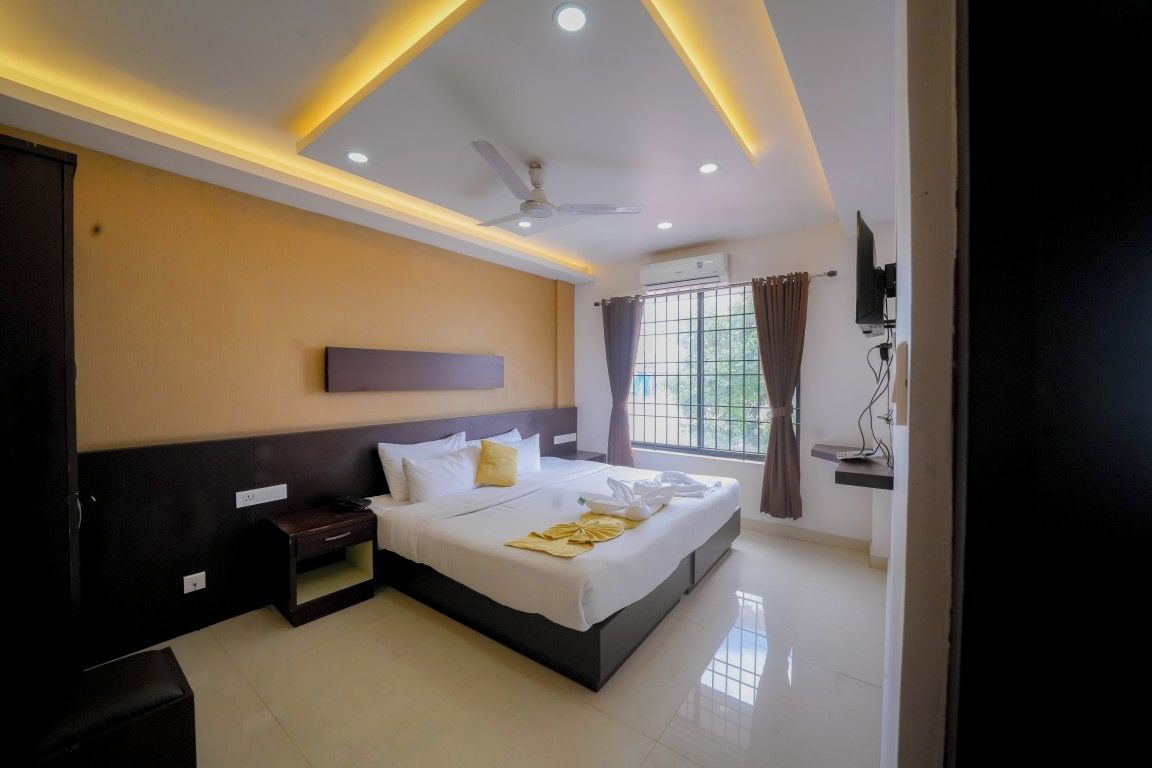 A hotel room with a bed, bedside table, and a television.