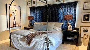 A four-poster bed with a canopy, a nightstand with a lamp, and a wall-mounted air conditioning unit.