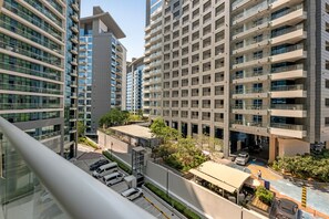 A high-rise residential building with multiple balconies, a rooftop garden, and a parking area. - Luxury Studio on the Palm | Beach & Rooftop Pool (Dubai)