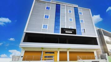 A multi-story building with a sign indicating it is a company-serviced townhouse.