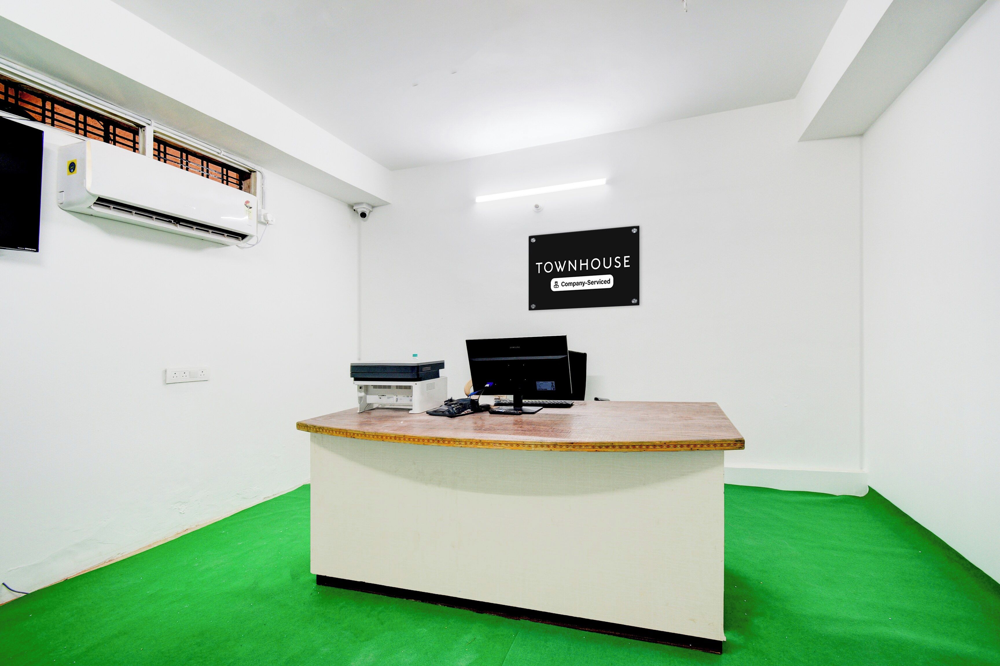 A reception desk with a sign indicating it is a company-serviced townhouse.