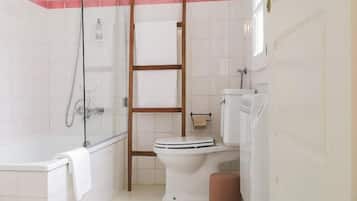 Un baño con bañera, inodoro y ducha.