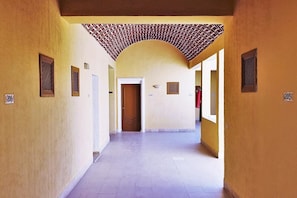 A corridor with a tiled ceiling, doors, and numbered signs. - Sun Palm  (Douz Nord)