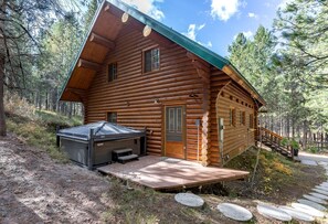 Eine Blockhütte mit einer Veranda, einer finnischen Sauna und einer Treppe zum Balkon.