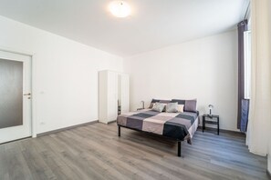 A bedroom with a bed, a nightstand, a wardrobe, and a door. - A comfortable and bright 74 square meters apartment, perfect for four people, located on the second floor of a period building (no elevator).The property is situated near the Ospedale Maggiore in Trieste and a short distance from the city center; guests  (Trieste)