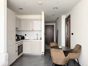 Une cuisine moderne avec un coin repas, comprenant un îlot central, des appareils électroménagers intégrés et un espace pour s’asseoir.