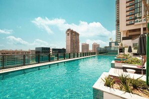 A rooftop swimming pool with a view of surrounding buildings. - Sunlit High-Floor 1BR | Sobha The Crest Tower B (Dubai)