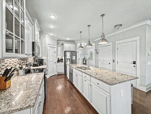 A modern kitchen with white cabinetry, granite countertops, and stainless steel appliances. - Luxury Beach House | Private Heated Pool, Lagoon Views & Games | Walk to Beach (Hilton Head Island)
