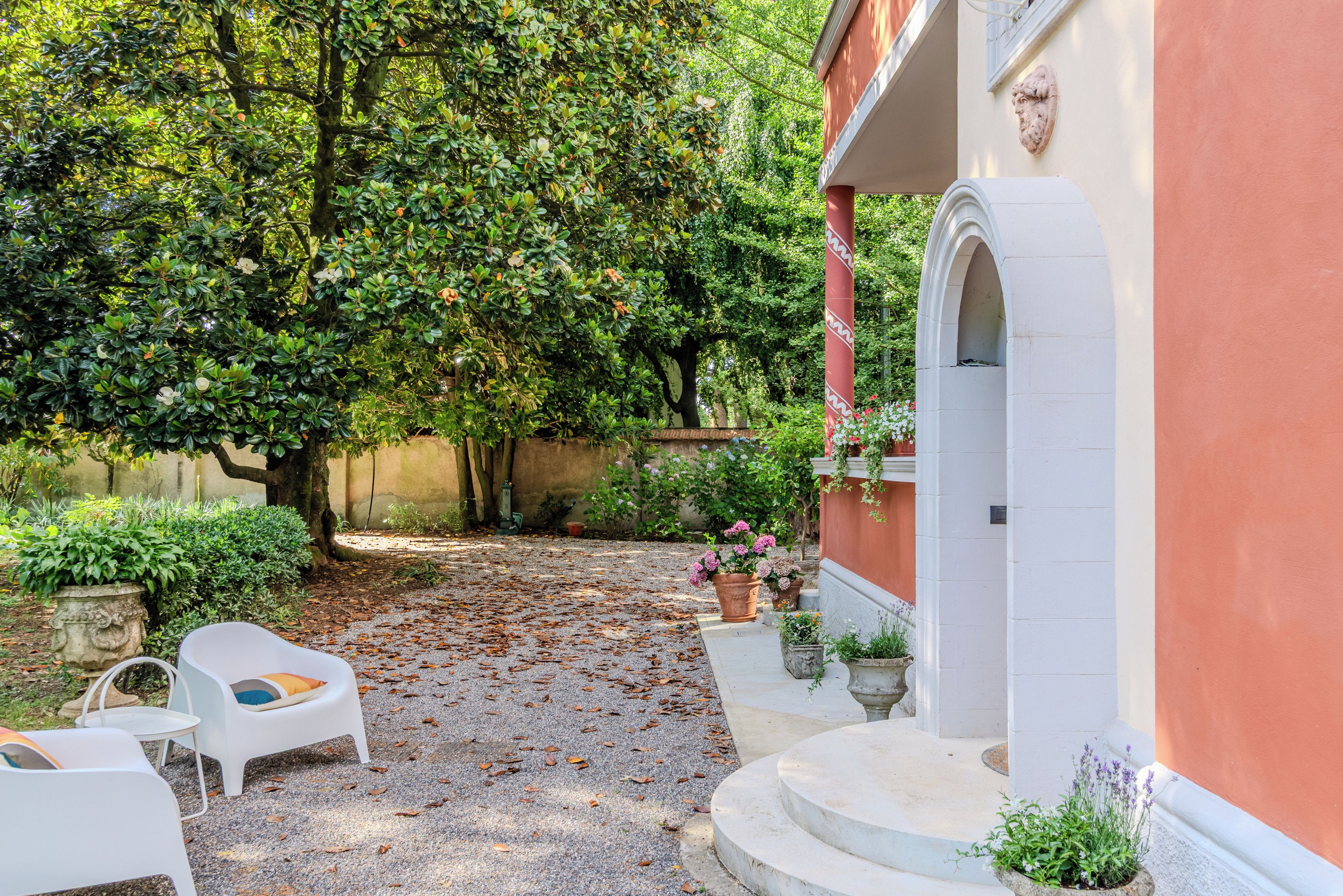 Ein Innenhof mit einem roten Gebäude, einem weißen Stuhl und einer Steinsitzbank.