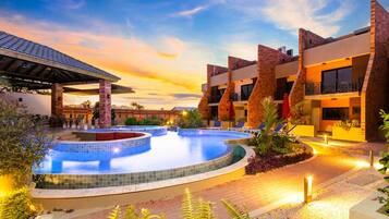 Un hôtel doté d'une piscine, d'un espace extérieur aménagé et offrant une vue sur le coucher de soleil.