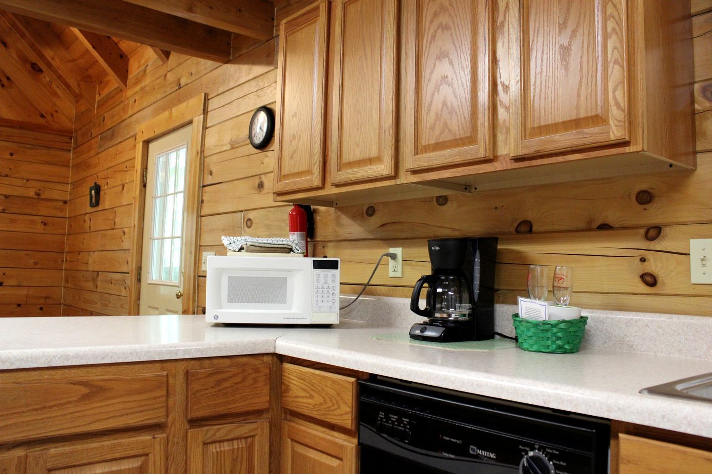 A kitchen with wooden cabinets, a microwave, a coffee maker, and a dishwasher.