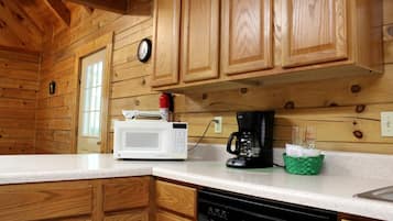 A kitchen with wooden cabinets, a microwave, a coffee maker, and a dishwasher.