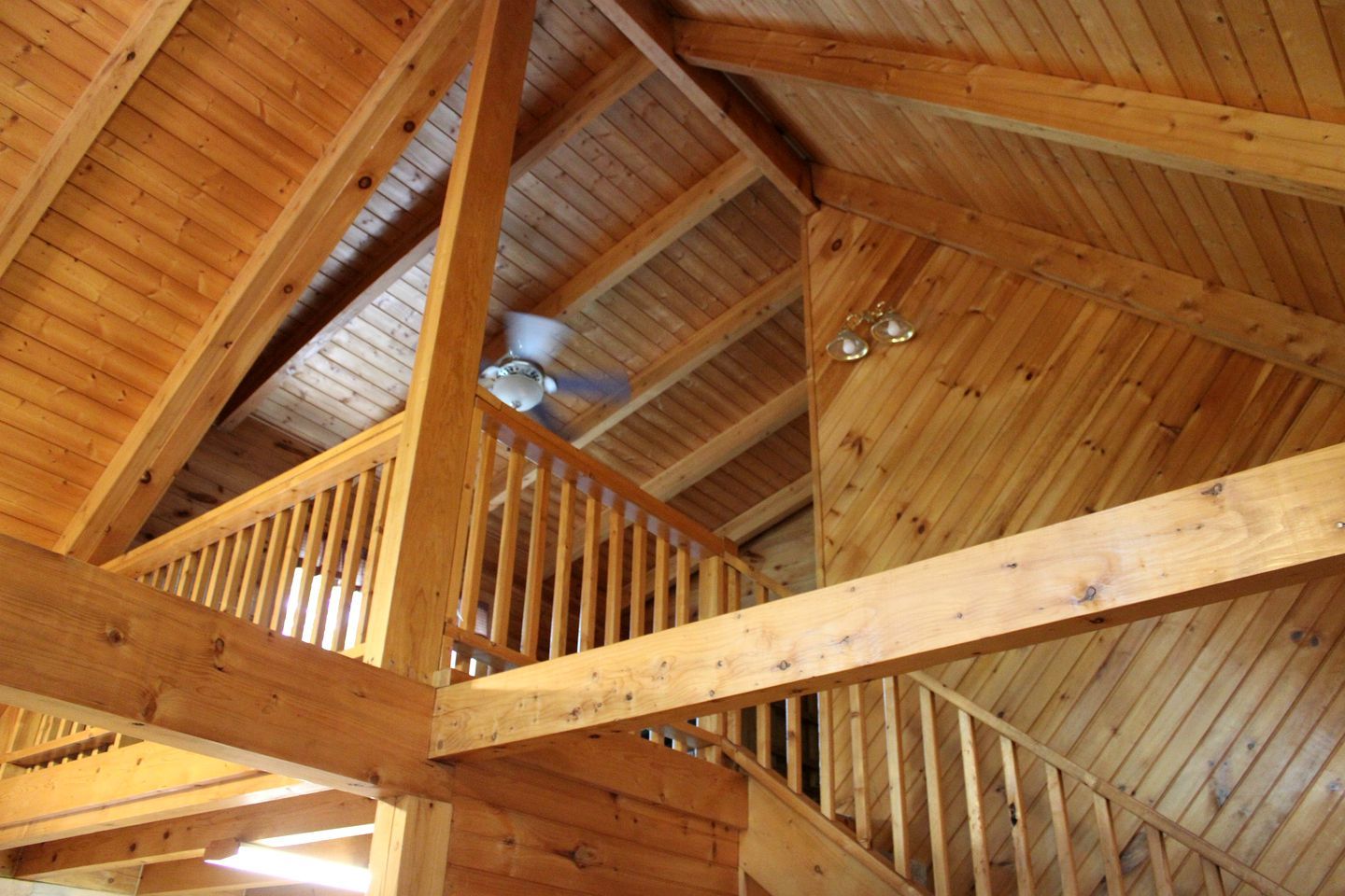 Un intérieur en bois avec un plafond haut et des poutres apparentes.