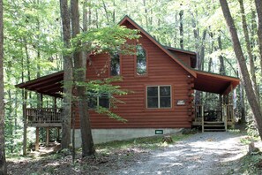 A cabin with a porch, a deck, and a sign indicating a lost paddle. - Idyllic Cabin Rental Nestled in the Forest near Summersville, West Virginia (Hico)
