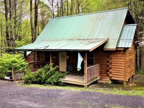 Eine rustikale Holzhütte mit Veranda, einer Flagge und einer Tür mit der Aufschrift 'HEROKEE'.